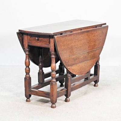 Lot 665 - An 18th century oak gateleg dining table, with...