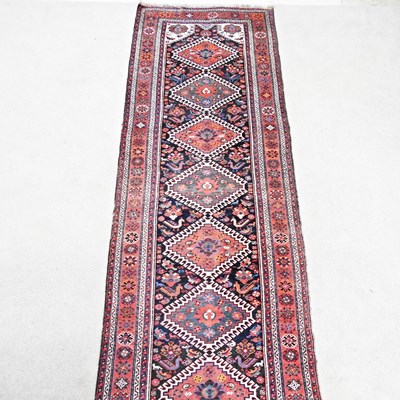 Lot 487 - A large Persian runner, with a row of eleven...