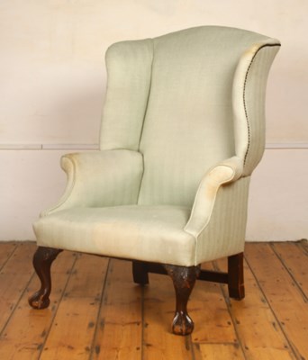 Lot 419 - A green upholstered wing back armchair