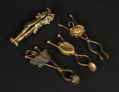Lot 234 - Three brass patterned skirt lifters or dress...