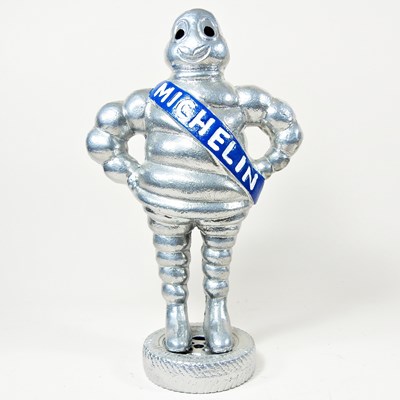 Lot 633 - A silver painted metal Michelin Man, 38cm high