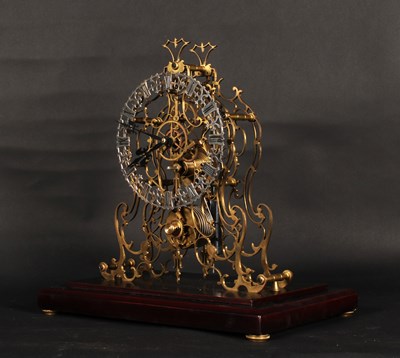 Lot 216 - A brass skeleton clock, the pierced chapter...