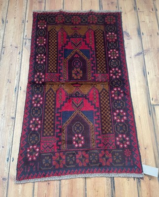 Lot 349 - A Baluchi rug, on a red ground