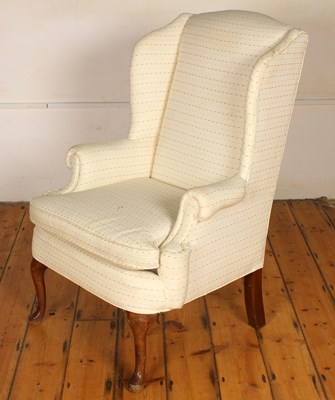 Lot 560 - A white upholstered wing back armchair