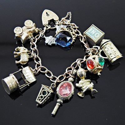 Lot 8 - A gold charm bracelet, suspended with a...