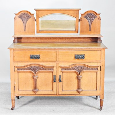 Lot 332 - An Art Nouveau oak sideboard, with a shaped...
