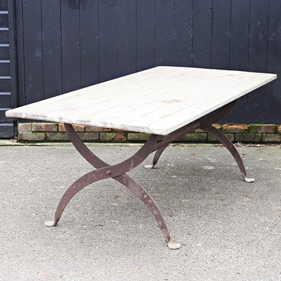 Lot 334 - A rustic wooden dining table, on a cast iron X...