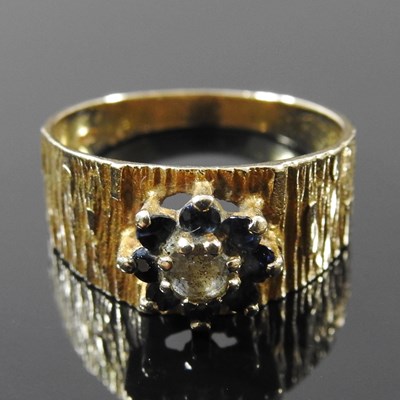 Lot 44 - A 9 carat textured gold, sapphire and diamond...