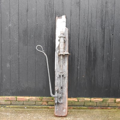 Lot 630 - A large garden water pump, mounted on a wooden...