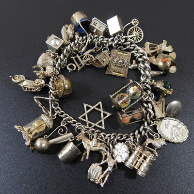 Lot 54 - A charm bracelet, suspended with a collection...