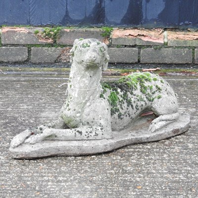 Lot 605 - A cast stone figure of a recumbent dog, 63cm long