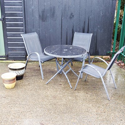 Lot 599 - A garden table and three chairs, together with...