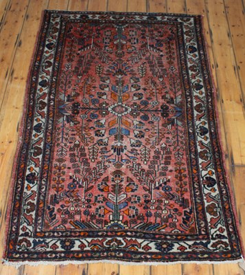 Lot 336 - A Persian wool rug, on a red ground, 207x136cm
