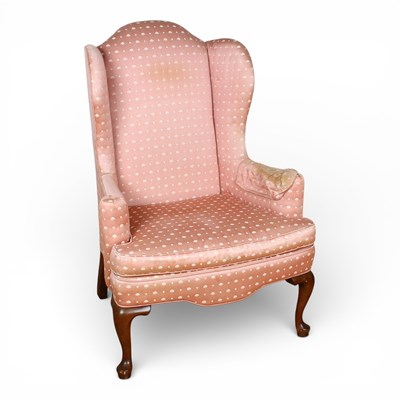 Lot 582 - A pink silk upholstered wingback armchair, on...