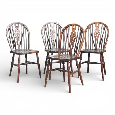 Lot 101 - A set of four wheelback dining chairs, on...