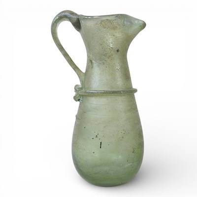 Lot 37 - An ancient green glass pitcher, with an...