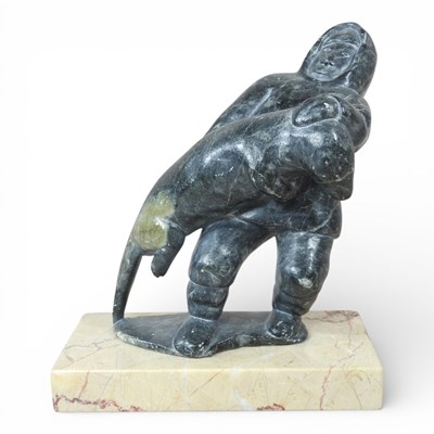 Lot 111 - Inuit school, 20th century, a hunter carrying...