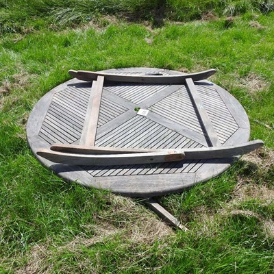 Lot 608 - A teak folding circular garden table