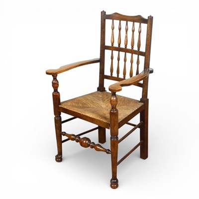 Lot 590 - An oak stick back rush seated chair