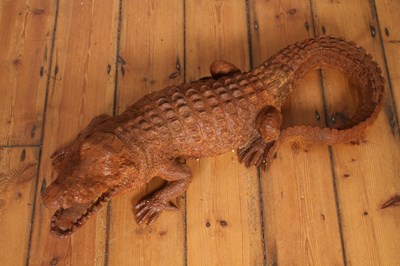 Lot 120 - A large rusted cast iron model of a crocodile,...