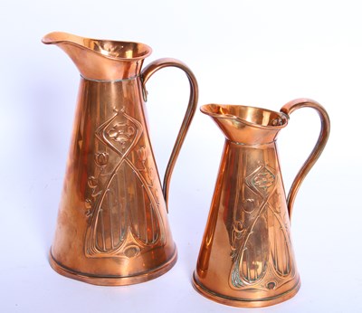 Lot 207 - A pair of Art Nouveau copper graduated jugs by...