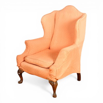 Lot 633 - A pink upholstered wing armchair, on cabriole...