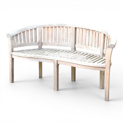 Lot 349 - A teak garden bench, of curved design
