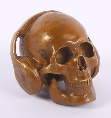 Lot 765 - A bronze model of a skull head wearing headphones