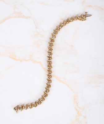 Lot 4 - A 14 carat yellow gold diamond tennis bracelet,...