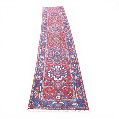 Lot 147 - A large Persian Heriz runner, with hooked...