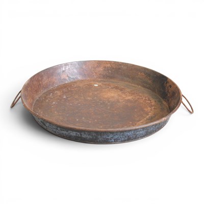 Lot 563 - A large metal skillet, flanked by loop handles,...