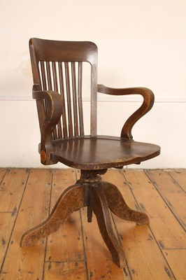 Lot 599 - An oak swivel desk chair