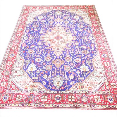 Lot 512 - A Persian heriz carpet, with scrolling foliate...