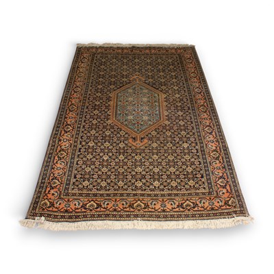 Lot 603 - A Persian blue rug with a large central...