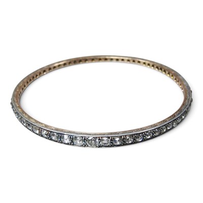 Lot 127 - A two colour gold bangle, of graduated shape,...