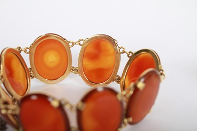 Lot 14 - A 9 carat yellow gold agate cabochon ring and...