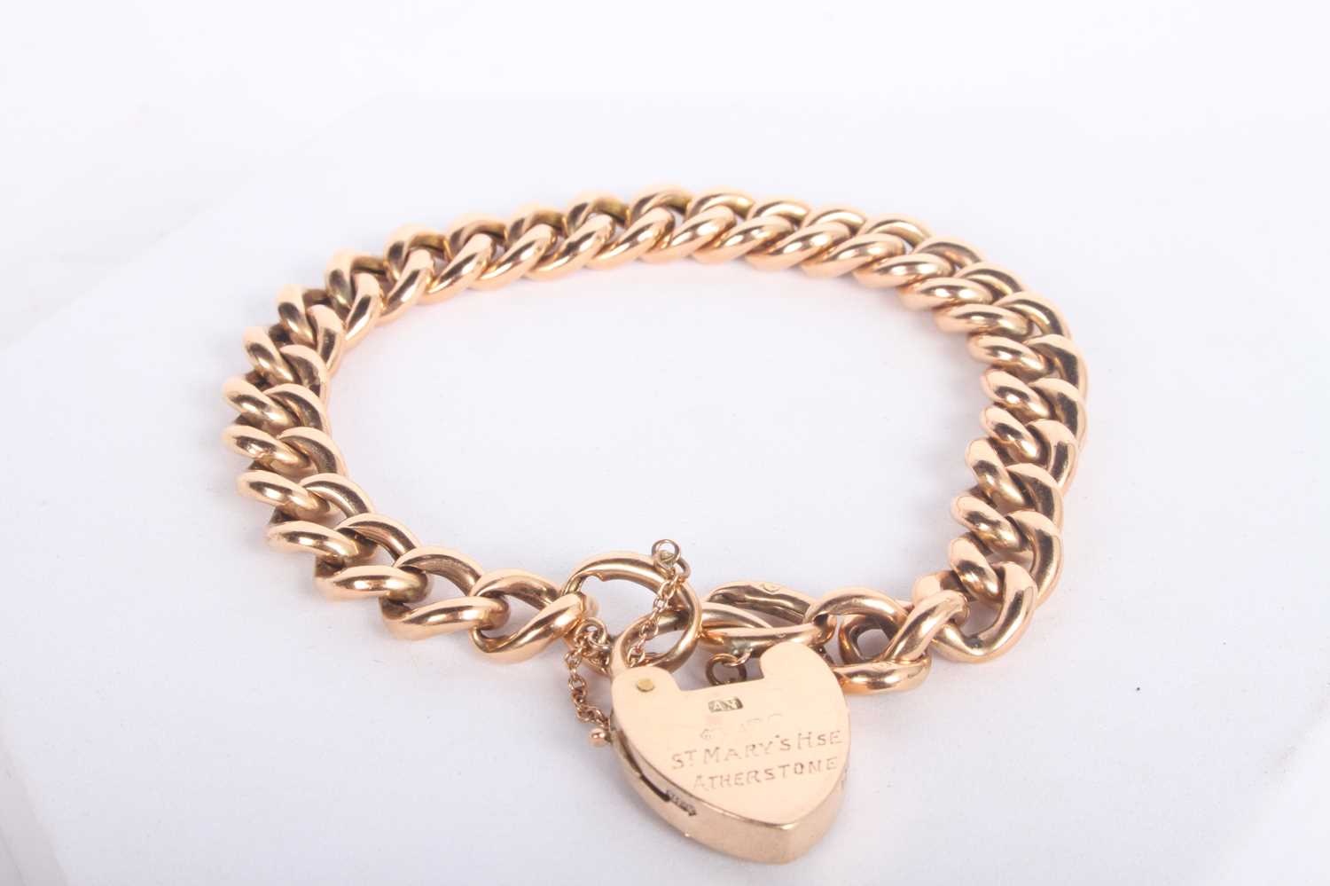 Lot 11 - A 9 carat gold curb link bracelet, with heart...