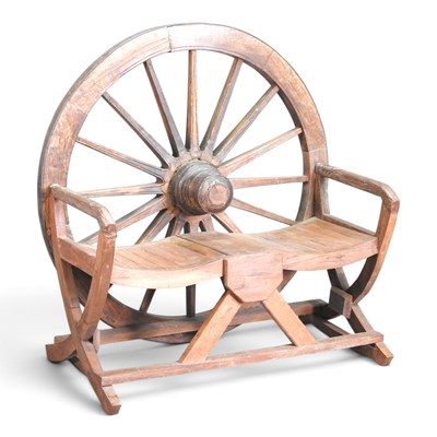 Lot 423 - An Indonesian teak cartwheel garden bench, on...