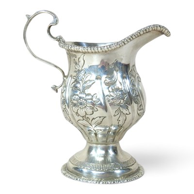 Lot 61 - An Edwardian silver cream jug, with repousse...