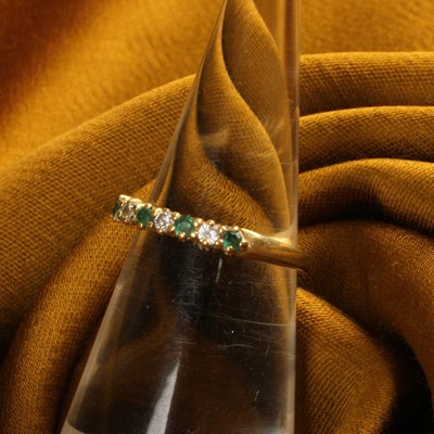 Lot 30 - An 18 carat gold emerald and diamond half hoop...