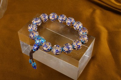 Lot 36 - A silver bead bracelet, having blue enamelled...