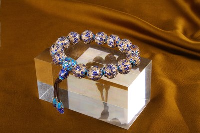 Lot 36 - A silver bead bracelet, having blue enamelled...