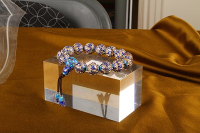 Lot 36 - A silver bead bracelet, having blue enamelled...