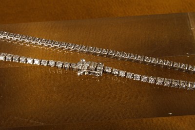 Lot 13 - A 9 carat white gold and diamond line bracelet,...