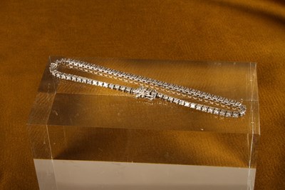 Lot 13 - A 9 carat white gold and diamond line bracelet,...