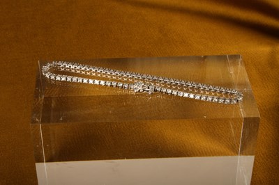 Lot 13 - A 9 carat white gold and diamond line bracelet,...