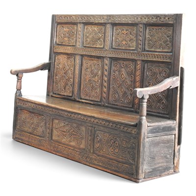 Lot 134 - An antique carved oak box settle, 18th century...