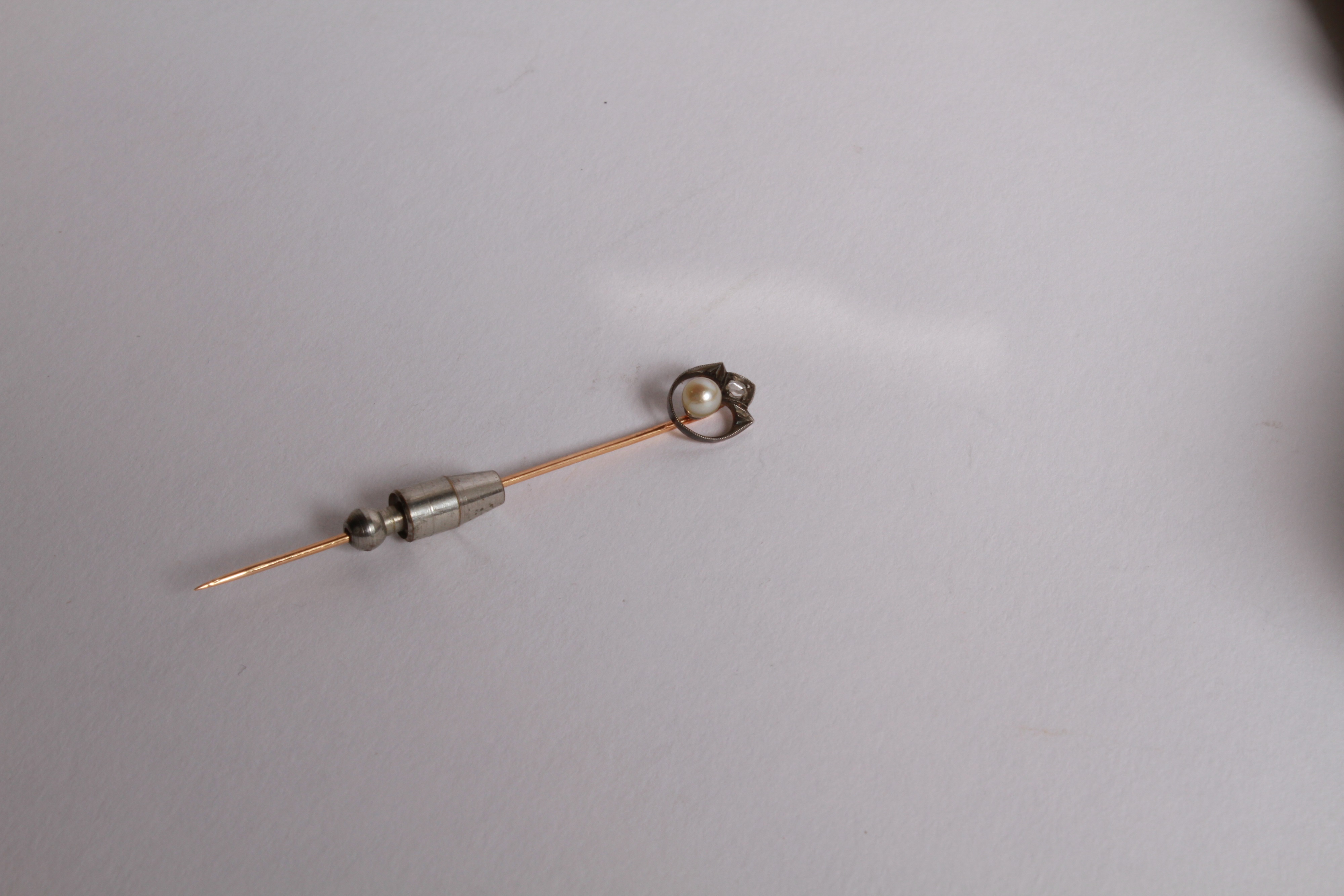 Lot 98 - A yellow metal stick pin with a diamond and