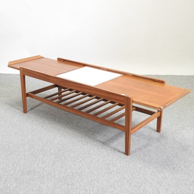Lot 661 - A mid 20th century teak pull out extending coffee table