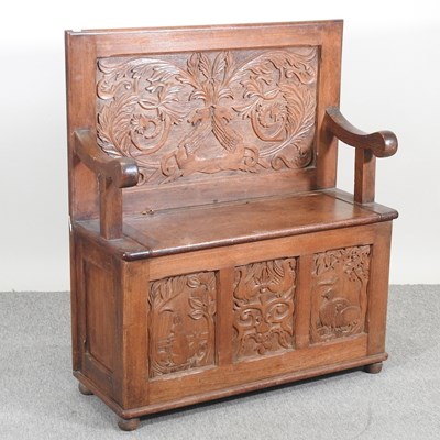 Lot 493 - An early 20th century carved oak box settle